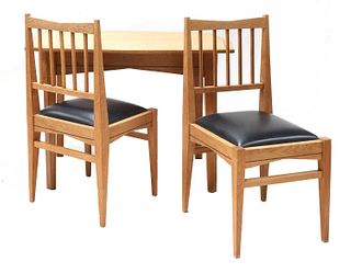 An oak dining table and two chairs,