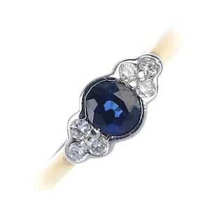 A sapphire and diamond ring. The circular-shape sapphire, with brilliant-cut diamond trefoil shoulde