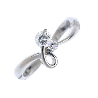 An 18ct gold diamond two-stone ring. Designed as a stylised bow with brilliant-cut diamond highlight