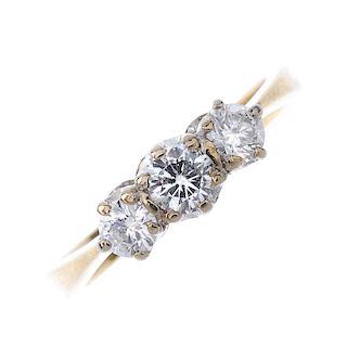 An 18ct gold diamond three-stone ring. The slightly graduated brilliant-cut diamond line, to the pla