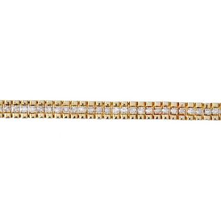 A 9ct gold diamond bracelet. Of bi-colour design, the brilliant-cut diamond line, to the polished si
