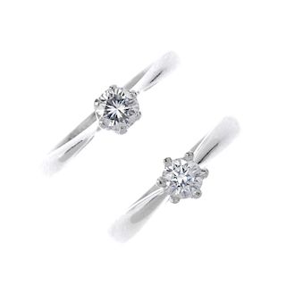 Two diamond single-stone rings. Each designed as a brilliant-cut diamond, to the tapered shoulders a
