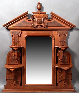 American Carved Walnut Overmantel Mirror, c. 1870, the broken arch crown with a central carved urn above a relief scrolled concentric carving, over a 