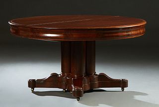 American Carved Mahogany Circular Dining Table, 19th c., the stepped sloping rounded edge top over a wide skirt, on a cluster column support, on quadr