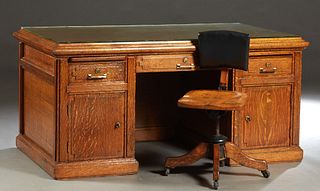 American Carved Oak Double Pedestal Desk, c. 1900, the stepped top over a center frieze drawer, flanked by pedestals with a pull out writing slide, ab