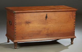 American Carved Walnut Blanket Chest, 19th c., the sides with folding iron handles, the interior with a candle box on one side, on turned tapered legs
