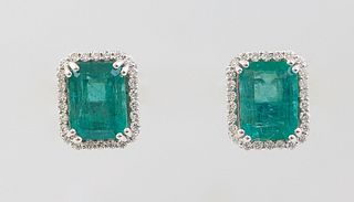 Pair of Platinum Stud Earrings, each with a 2.12 ct. emerald atop a border of tiny round diamonds, total emerald wt.- 4.24 cts., total diamond wt.- .3