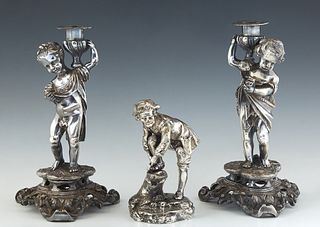 Pair of Silverplated Figural Candlesticks, late 19th c., with a male and female putto upholding a candle cup on one shoulder, on a tripartite plinth a