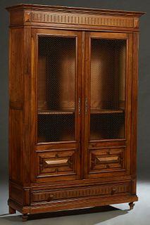 French Henri II Style Carved Walnut Bookcase, early 20th c., the stepped crown over double doors with brass wire mesh upper panels over applied geomet