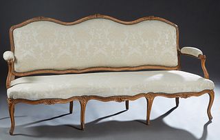 French Louis XV Style Carved Cherry Canape, 19th c., the serpentine upholstered back to upholstered arms and a serpentine upholstered seat, on carved 