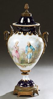 Large Sevres Style Covered Porcelain Bronze Mounted Baluster Urn, early 20th c., with cobalt and gilt decoration, the lid with an acorn finial, above 