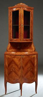 French Louis XV Style Marquetry Inlaid Bowfront Corner Cabinet, 20th c., with a carved crest over double curved glass doors, atop a marquetry inlaid b