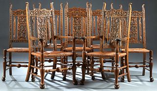 Set of Eight (6 + 2) English Carved Oak Dining Chairs, late 19th c., the high aesthetic carved back over flat like carved arms, to a rush seat, on tur