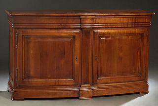 French Louis Philippe Carved Cherry Sideboard, late 20th c., the stepped rounded edge and corner top over three reeded frieze drawers, above double co