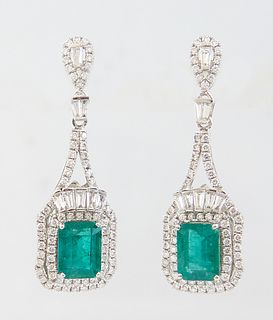 Pair of Platinum Pendant Earrings, with a baguette and round diamond mounted pear shaped stud, to a diamond mounted bail, over a pendant emerald atop 