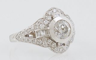 Lady's Platinum Dinner Ring, with a central round 1.02 carat diamond, within a diamond mounted lobed frame, flanked by baguette diamond mounted lugs, 
