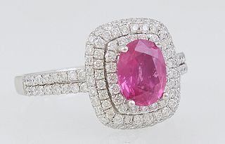 Lady's Platinum Dinner Ring, with an oval 1.29 ct. pink sapphire atop a double concentric graduated border of round diamonds, the shoulders of the ban