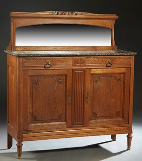 French Art Nouveau Carved Oak Marble Top Server, early 20th c., the splash back with a carved leaf and nut crest over an arched wide beveled mirror, o