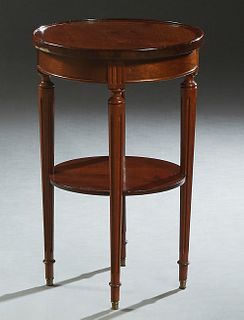 French Louis XVI Style Carved Mahogany Side Table, early 20th c., the dished circular top on turned tapered reeded legs, joined by a lower circular sh