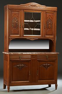 French Art Nouveau Carved Walnut Marble Top Buffet a Deux Corps, c. 1920, the fruit carved arched crown over a central beveled leaded glass door cupbo