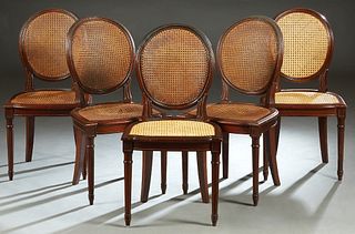 Set of Five French Louis XVI Style Carved Mahogany Dining Chairs, 20th c., the caned oval curved back over a bowed cane seat, on turned tapered reeded