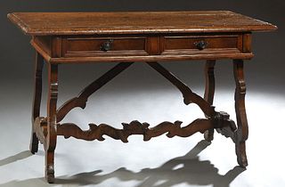 French Provincial Carved Oak Writing Table, 19th c., the rounded edge top over two frieze drawers, on cabriole leg open trestle bases joined by serpen