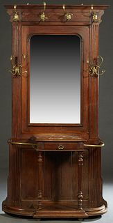 French Carved Oak and Brass Marble Top Hallstand, c. 1900, the stepped crown over four brass coat and hat hooks, above an arched wide beveled mirror p