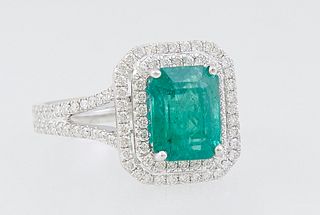 Lady's 18K White Gold Dinner Ring, with a 2.46 ct. emerald atop a pierced double concentric graduated border of round diamonds, total diamond wt.- .65