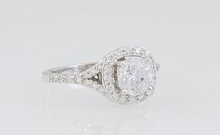 Lady's 14K White Gold Dinner Ring, with a 1.12 ct. round diamond atop a border of round diamonds, the split shoulders of the band also mounted with ro