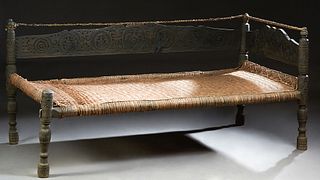 Antique Pakistan Provincial Carved Ebonized Day Bed, 19th c., from the Swat valley, with turned posts and a floral carved headboard and back, with a w