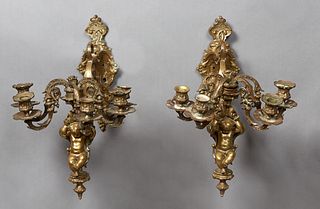 Pair of Large Bronze Putto Sconces, 19th c., the scrolled relief fish and grape bunch back plates issuing a central scrolled arm with a putto terminal