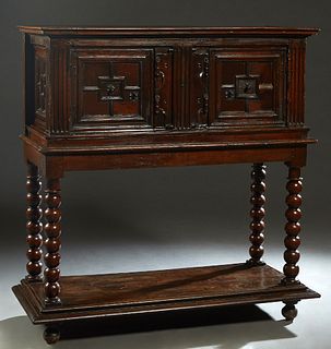 French Provincial Louis XIII Style Carved Walnut Sideboard, 19th c., the stepped crown over double cupboard doors with iron pulls, separated by a carv