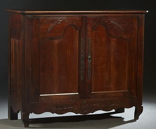 French Louis XV Style Carved Walnut Sideboard, 19th c., the canted corner top over leaf carved double cupboard doors with long iron escutcheons and fi