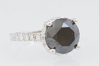 Lady's 14K White Gold Dinner Ring, with a circular 5.14 carat black diamond, atop a platform with diamond mounted edges, the shoulders of the band als
