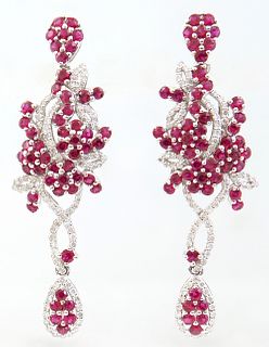 Pair of Platinum Pendant Earrings, each with a ruby mounted stud suspending a ruby mounted pendant with diamond mounted swirled "ribbons," suspending 