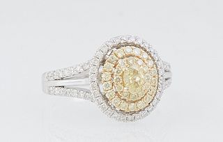 Lady's 14K White Gold Dinner Ring, with an oval .24 ct. fancy light yellow diamond and an inner yellow diamond bezel, and an outer white diamond bezel