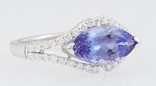 Lady's 18K White Gold Dinner Ring, with a 2.45 ct. marquise tanzanite atop a split top with a border of small round diamonds, the split shoulders of t