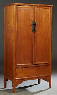 Chinese Carved Mahogany Armoire, late 19th c., the stepped rounded corner crown over double doors with brass pulls, on engaged cylindrical supports jo