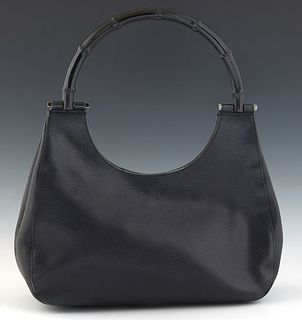 Gucci Bamboo Hobo Bag, in black small grained calf leather with a black bamboo handle and ruthenium hardware, the magnetic snap closure opening to a b