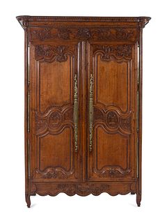 A Louis XV Provincial Brass Mounted Carved Oak Armoire