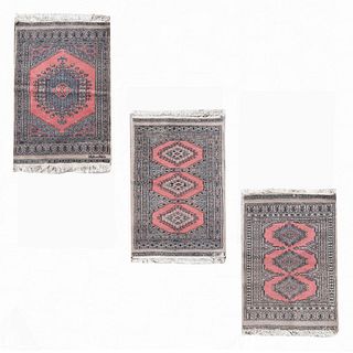 Lote de 3 tapetes, pie de cama. S XX. Estilo bokhara. Elaborados en fibras de lana y algodón. Decorados con motivos geométricos.