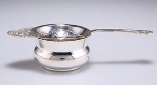 A GEORGE VI SILVER TEA STRAINER ON STAND, by Robert Edgar S