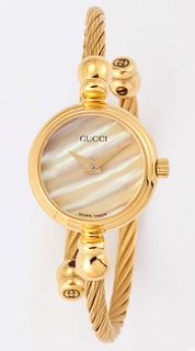 A LADY'S GOLD PLATED GUCCI BANGLE WATCH, circular mother-of