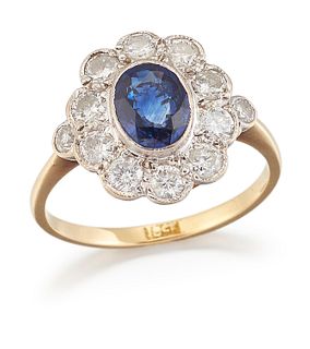 A SAPPHIRE AND DIAMOND CLUSTER RING, a oval-cut sapphire wi