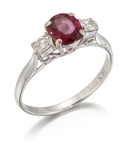 A RUBY AND DIAMOND THREE STONE RING, an oval-cut ruby betwe