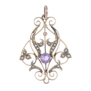 An early 20th century 9ct gold amethyst and split pearl pendant. Designed as openwork scrolls, with