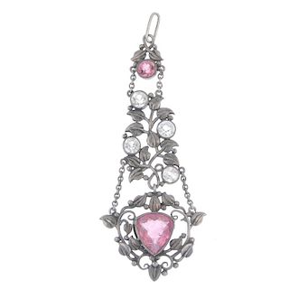 An early 20th century silver tourmaline and topaz pendant. The central triangular pink tourmaline wi