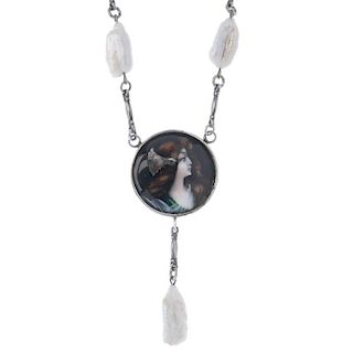 An Art Nouveau pendant and chain. The circular pendant set with a Limoges style panel depicting a yo