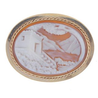 A 9ct gold cameo brooch. Of oval outline and depicting a house by a body of water. Hallmark illegibl