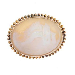 A cameo brooch. Depicting a building in a countryside setting, to the twisted surround. Length 3.6cm